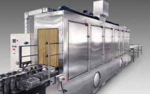 Conveyor washer to clean totes and engine blocks