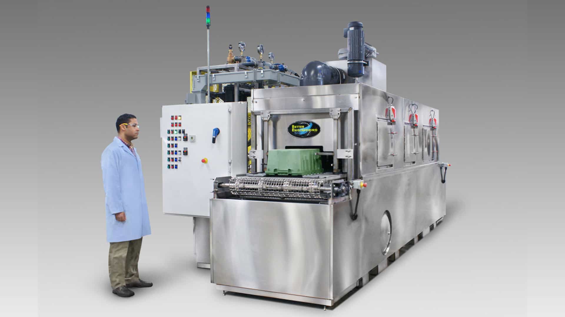 Conveyor belt washer for cleaning totes and trays used in food distribution