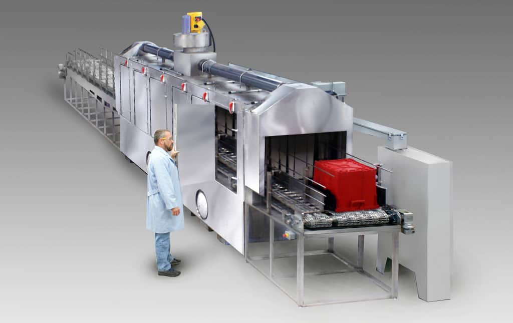 Conveyor belt washer for cleaning and sanitizing medical waste containers