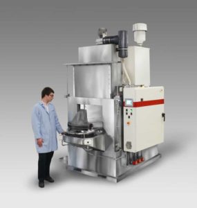 Work cell vertical door parts washer to clean transmission housings