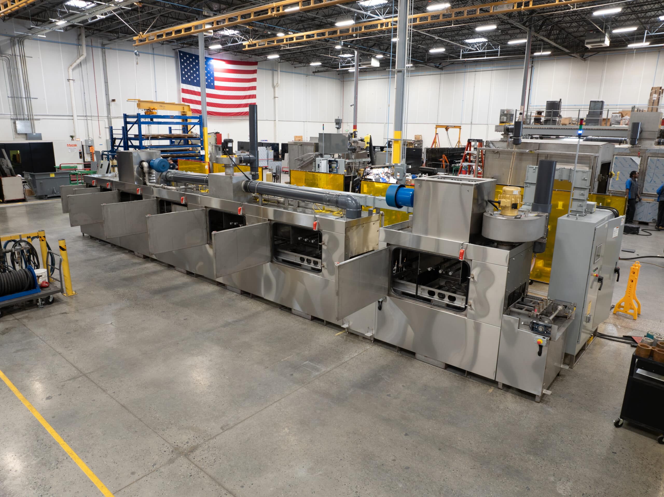 Conveyor part washer to clean wheel hubs.
