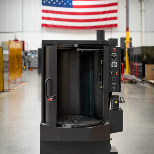 Better Engineering's parts washer displayed in a U.S. manufacturing facility beneath a large American flag.