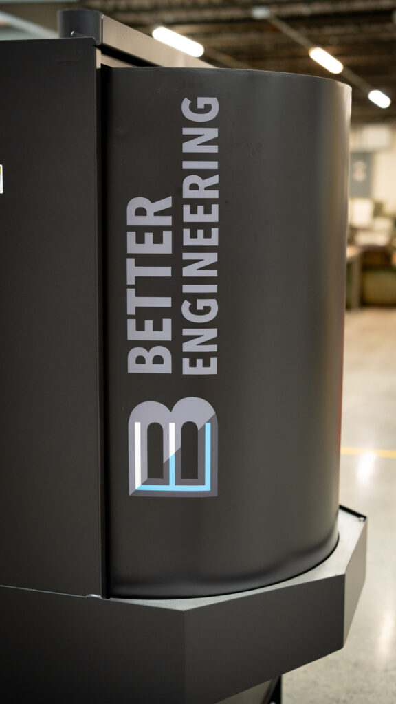 Modern parts washer by Better Engineering showcased in a manufacturing space with an American flag in the background.