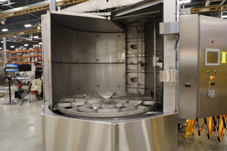 Better Engineering stainless steel sanitizing turntable washer; equipped with multiple cleaning stages.