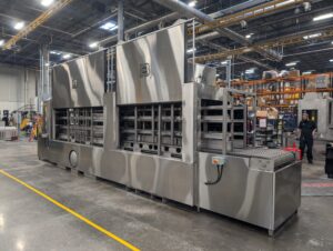 Automotive parts washer designed to remove contaminants from dunnage.