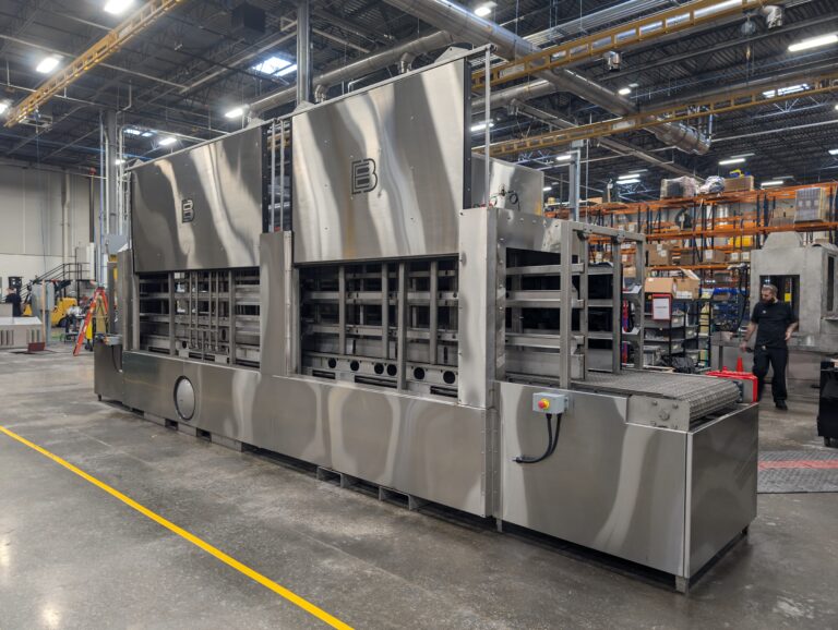 Automotive parts washer designed to remove contaminants from dunnage.