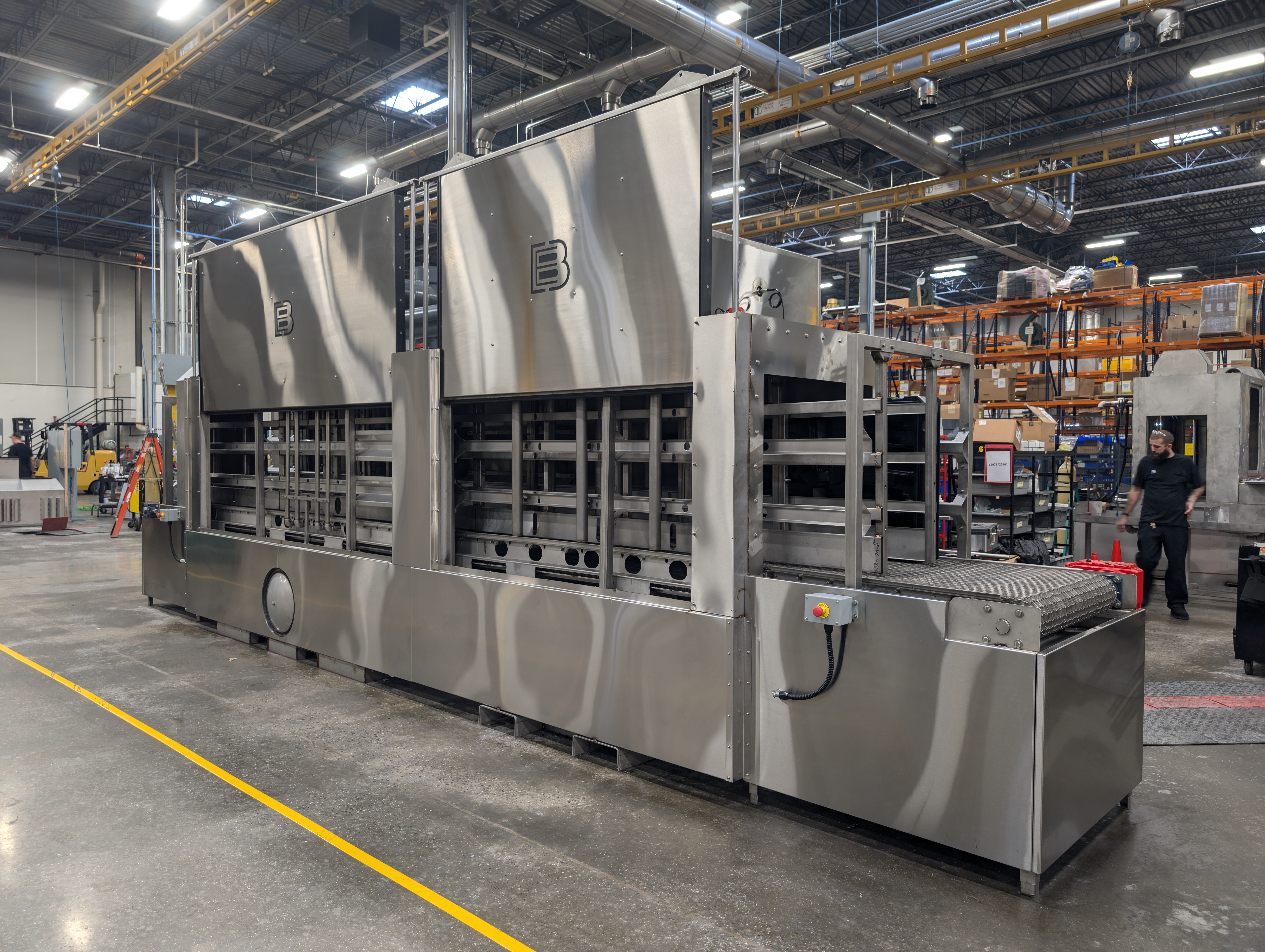 Automotive parts washer designed to remove contaminants from dunnage.