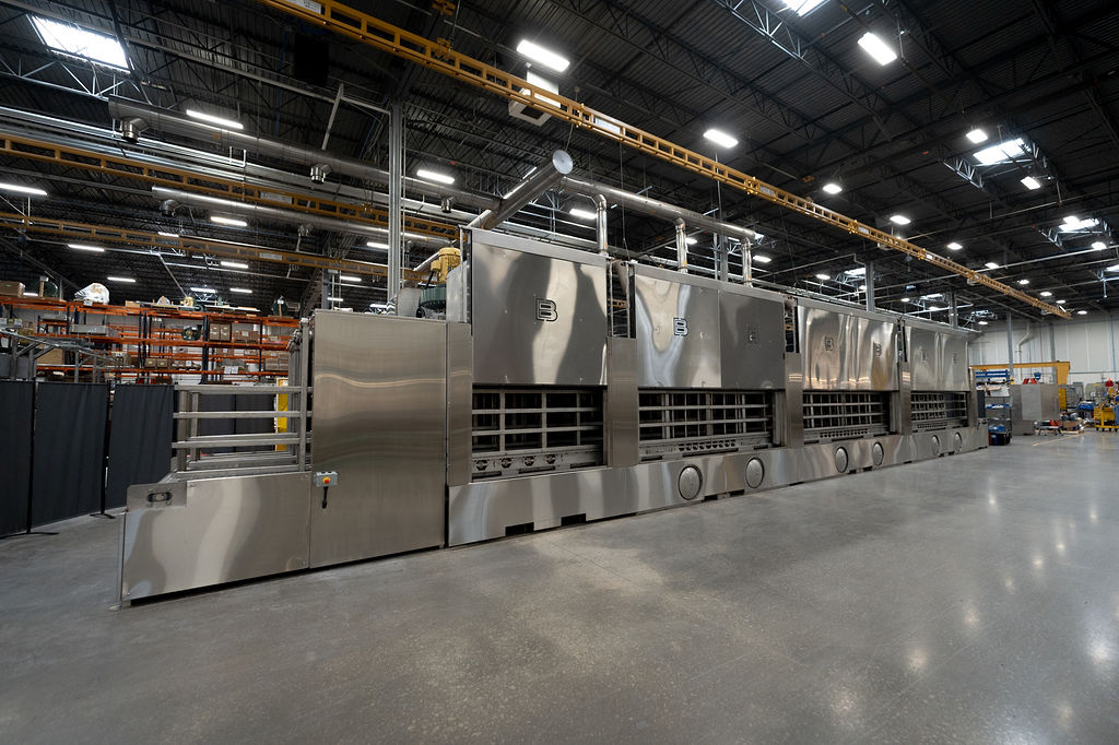 Tunnel washing system designed to clean returnable dunnage.