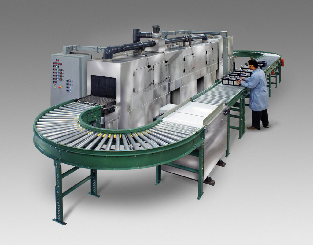 Conveyor Washer designed to clean small metal parts secured inside baskets.