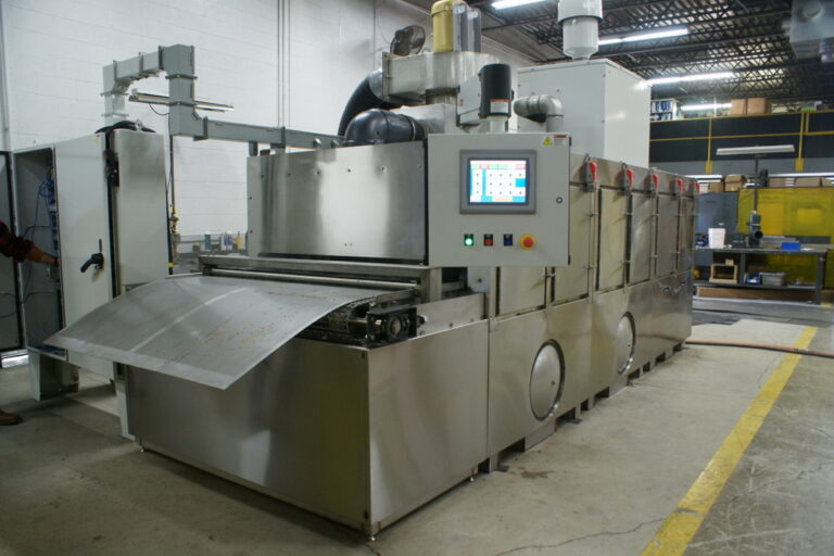 Conveyor Washer designed to clean perforated aluminum materials.